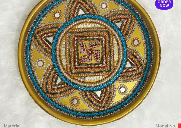 A round, gold-colored, stainless steel plate is decorated with intricate, symmetrical designs